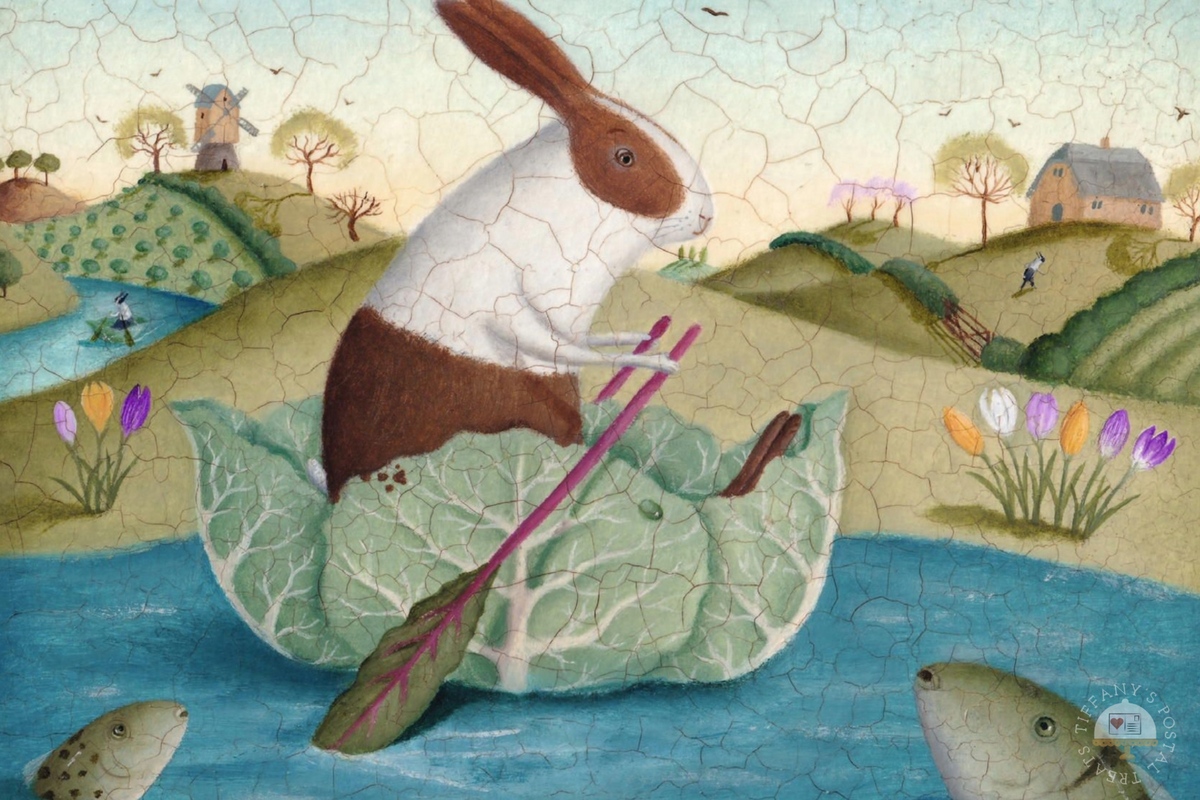 Spring Rabbits Postcard by Inkognito featuring a whimsical folk-art style illustration of a brown-and-white rabbit rowing in a large cabbage boat on blue water, with rolling green hills, flowers, trees, a windmill, and a house in the background. The artwork has a visible crackle texture across the entire scene.