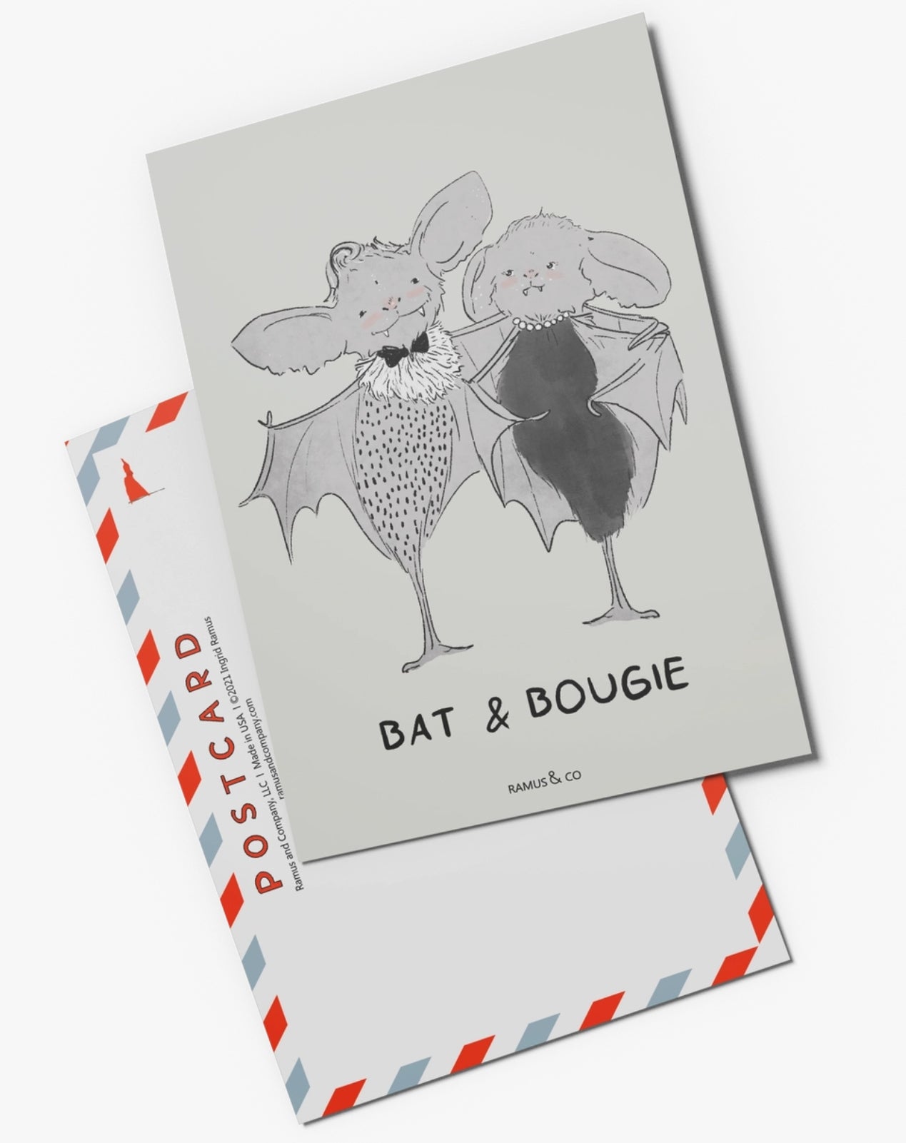 Bat & Bougie Postcard by Ramus & Company featuring a whimsical illustration of two cute bats looking fancy and standing together. The postcard is labeled 'BAT & BOUGIE' and is shown layered over its postcard back.