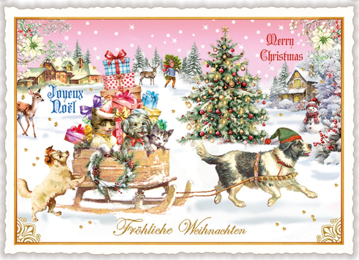 Christmas Dogs Postcard by Edition Tausendschön featuring a snowy winter village scene with dogs pulling a sleigh loaded with wrapped gifts and cats and a dog, a decorated Christmas tree, reindeer, and the text 'Merry Christmas' in the background