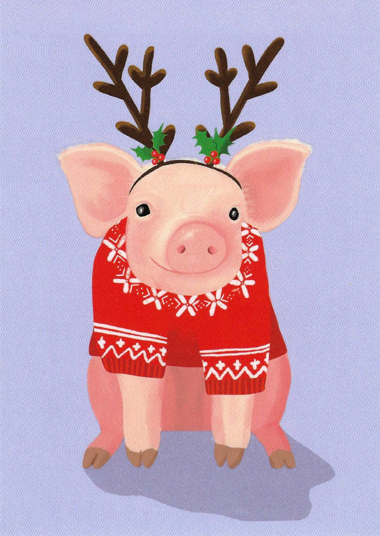 Christmas Pig Postcard by Toni Starck for Nobis Design featuring a cute pig wearing a red Christmas sweater with white patterns, brown reindeer antlers with green holly accents, against a light lavender background.