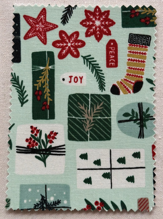Fabric postcard with Christmas-themed pattern on a mint green background.