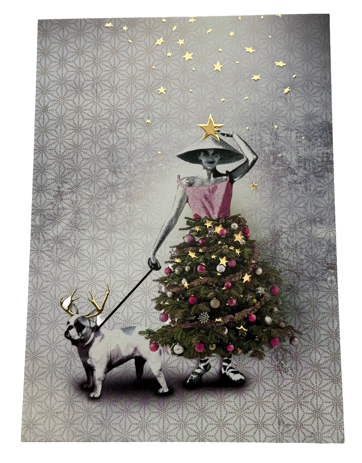 Christmas Tree Dress Postcard by La Tack for Nobis Design featuring a woman in a conical hat and pink dress walking a dog on a leash, with the dog wearing a reindeer antler headband. The woman's dress is shaped like a decorated Christmas tree, and gold stars decorate the gray patterned background.