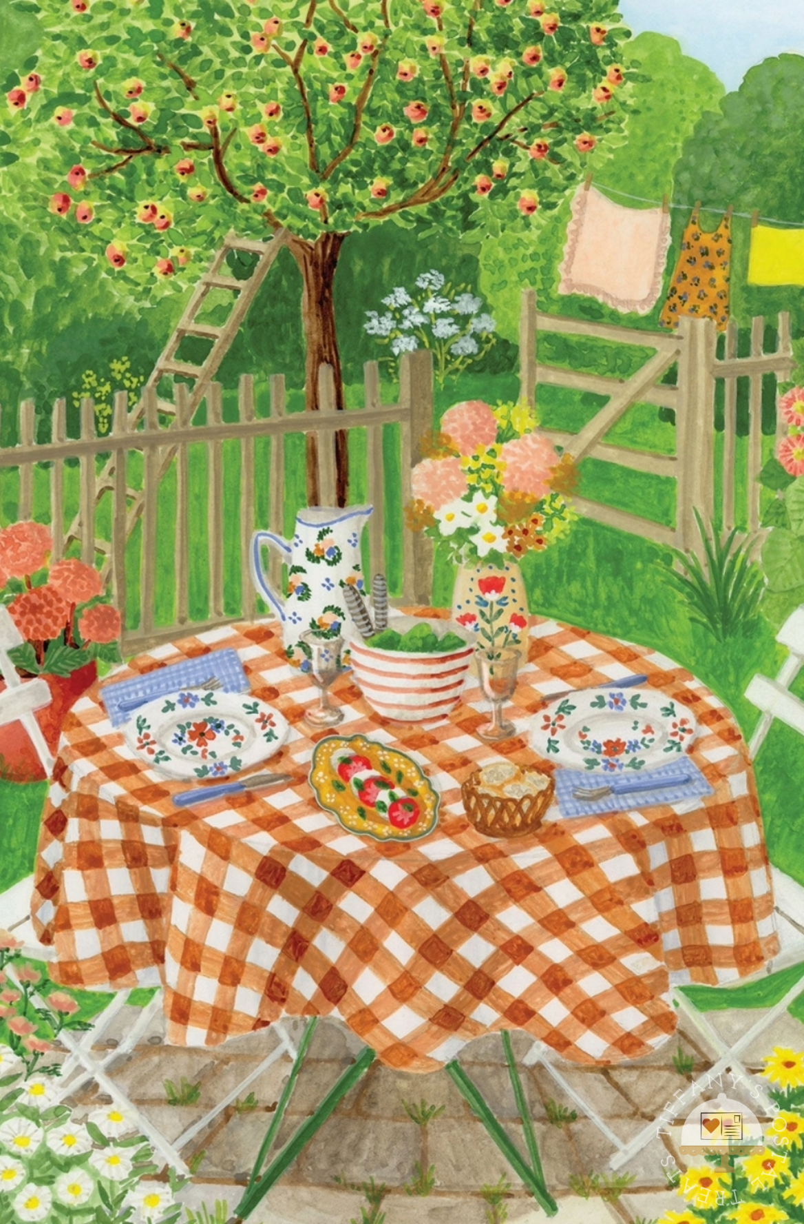 Lunch in the Garden by Mélanie Voituriez featuring a colorful illustrated outdoor garden scene with a round table set for two, covered in an orange-and-white checkered tablecloth. The table holds floral plates, a pitcher, a striped bowl, flowers, and a basket of bread, with a wooden fence, greenery, and hanging garments in the background.