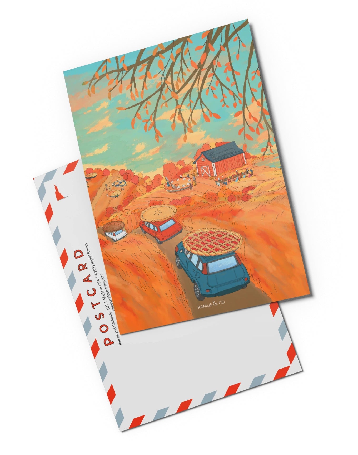 Pie Club Postcard by Ramus & Company featuring a colorful rural autumn landscape, with cars with pies on top, a red barn, and tree branches overhead, shown with the postcard back behind it.