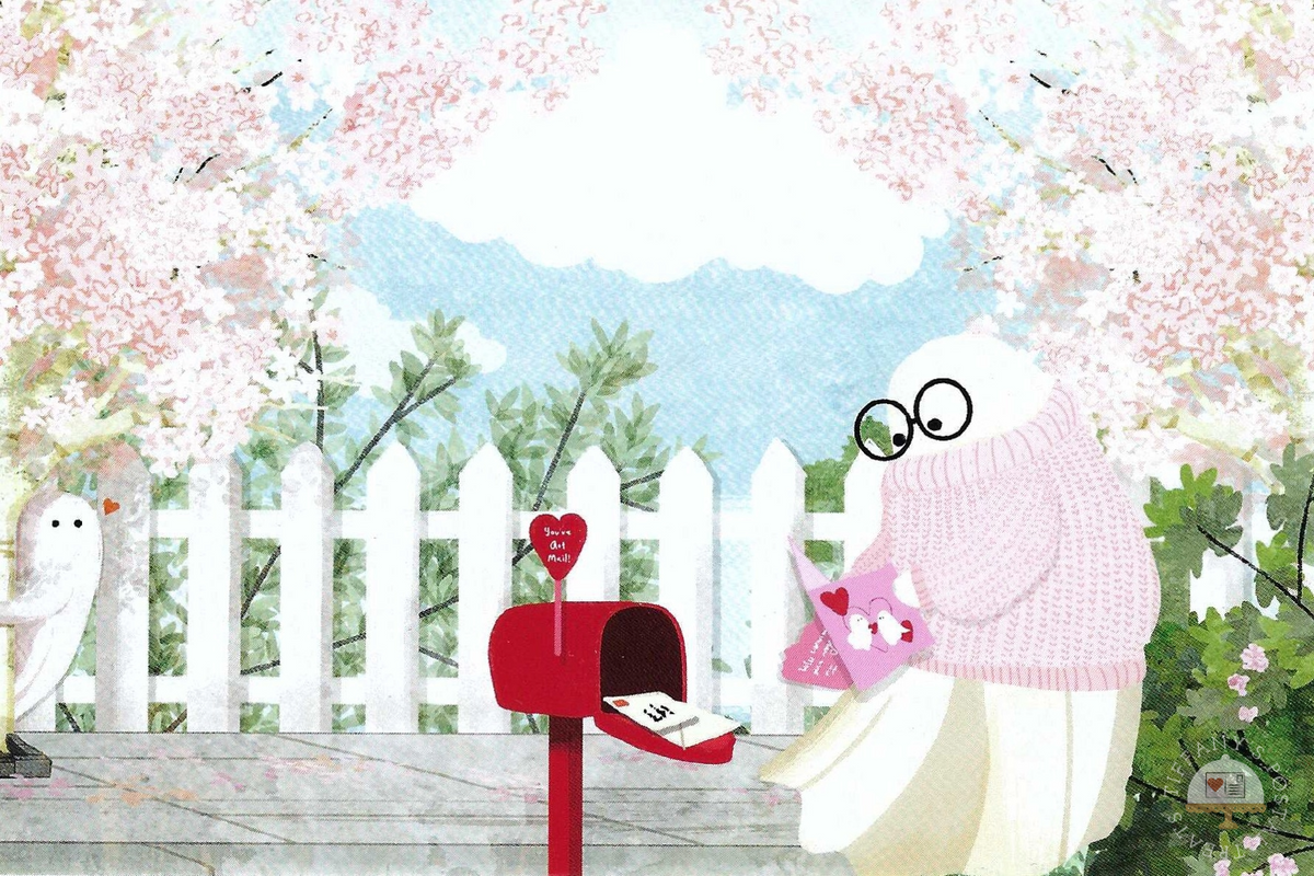 My Shy Valentine Postcard by Katherine Blower featuring a ghost wearing a pink knit sweater and glasses, holding a Valentine's card near an open red mailbox. A white picket fence, pink cherry blossoms, another ghost with a red heart and a blue sky are in the background.