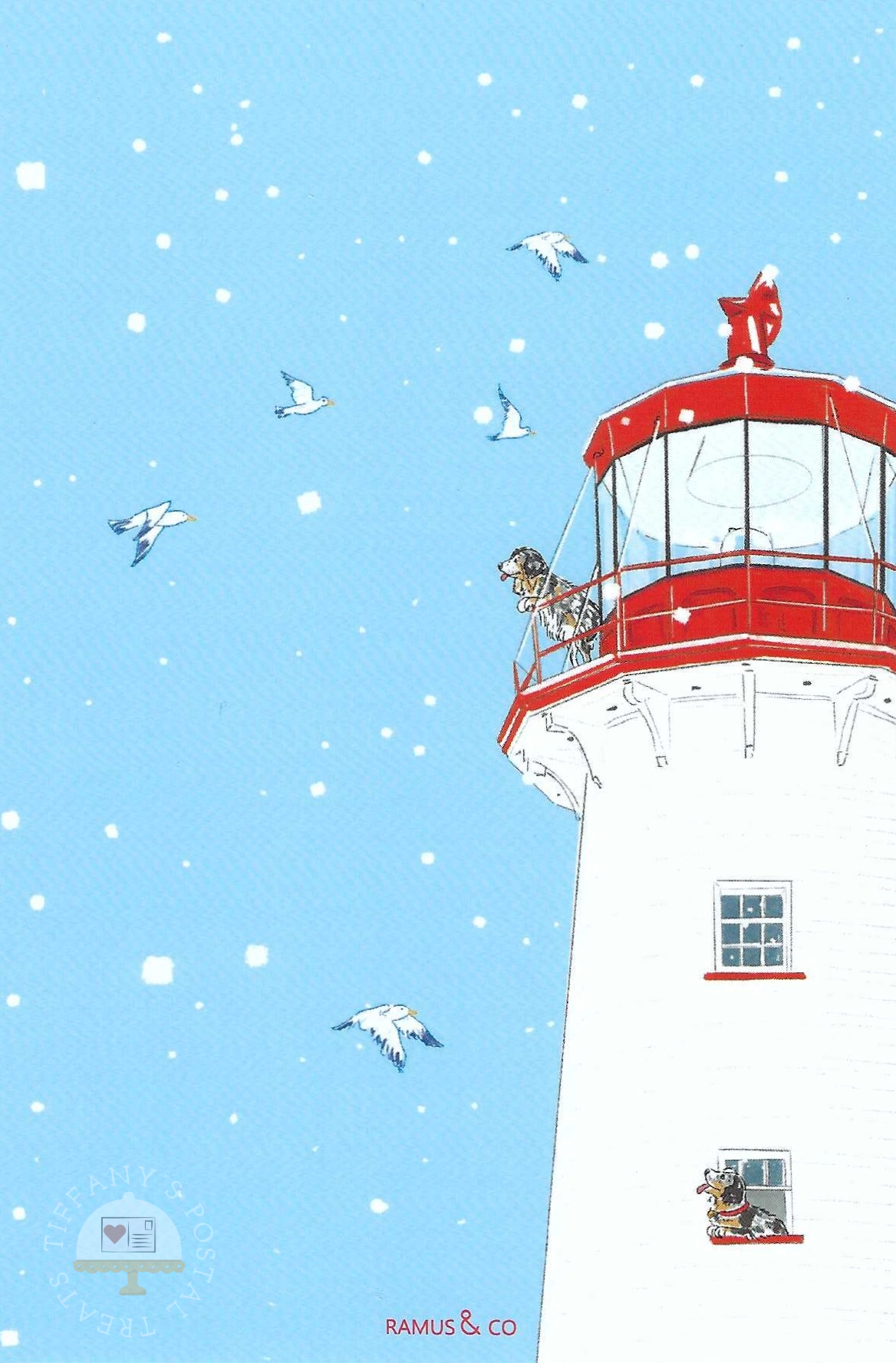 Winter Dogs Lighthouse Postcard by Ramus & Company showing a white lighthouse with a red lantern room, set against a light blue snowy sky with flying seagulls and a dog looking out from the lighthouse. 